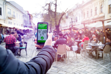 Obraz premium Person at the resturant using mobile app in phone to show immunization certificate.