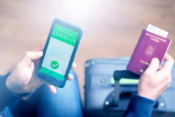 Person in airport using mobile app in phone to show covid-19 test results for travel