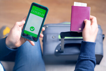 Person in airport using mobile app in phone to show covid-19 test results for travel
