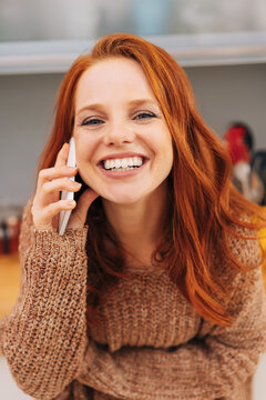 Vivacious smiling woman chatting on a mobile