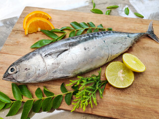 Closeup view of Tuna fish decorated with fruits and herbs on a wooden background,Selective focus.