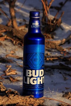 Bud Light in a blue metal bottle shot closeup with snow and tree's that's bright and colorful west of Hutchinson Kansas USA out in the country.