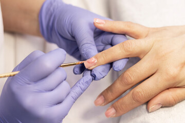 Manicure. Strengthening of natural nails with artificial material-gel. Nail care in a beauty salon. Close-up