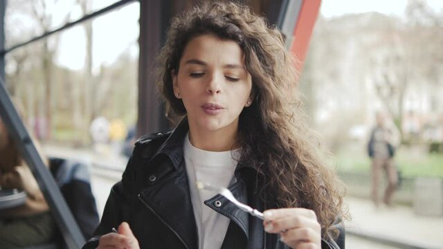 Pretty lovely woman eat pasta in italian cuisine restaurant funny suck it in mouth smile having fun using fork.A beautiful girl is having lunch in a restaurant.
