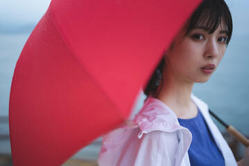 雨の中で傘を差す女性