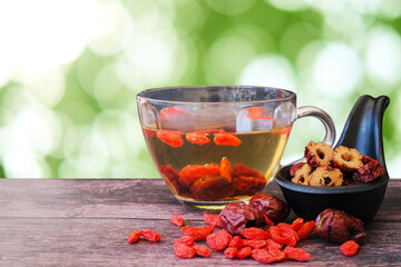 Healthy hot drink brewed from Chinese jujube and Chinese goji berries in glass and sliced Chinese...