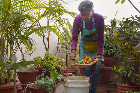A woman making compost from kitchen leftovers	