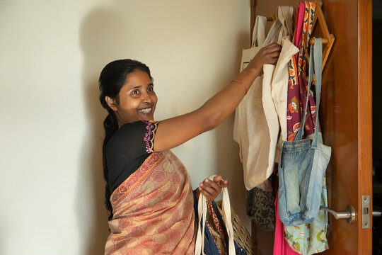 A home-maker carrying reusable cloth bags for shopping	