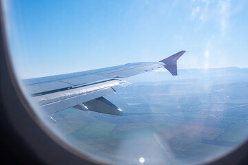 airplane window picture with sun on the horizon.