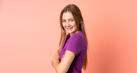 Obraz premium Teenager Ukrainian girl isolated on pink background with arms crossed and looking forward