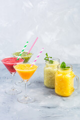 Sicilian Orange, Tangerine and Kiwi fruit smoothie served in martini glass and Orange and lime smoothie with mint in glass cups non-alcohol cocktail