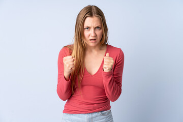 Fototapeta premium Teenager Ukrainian girl isolated on blue background frustrated by a bad situation