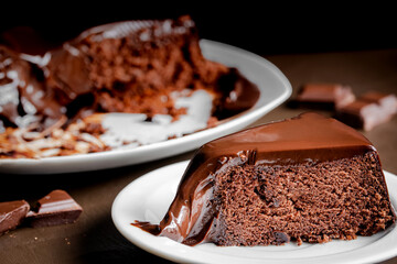 Chocolate cake slice in the white plate on the table.