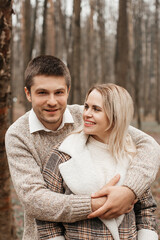 A young, loving couple have fun walking in nature in the rain.