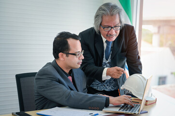 Two Businessmen Discussing Project on laptop in office and executive engineer is coaching his team...