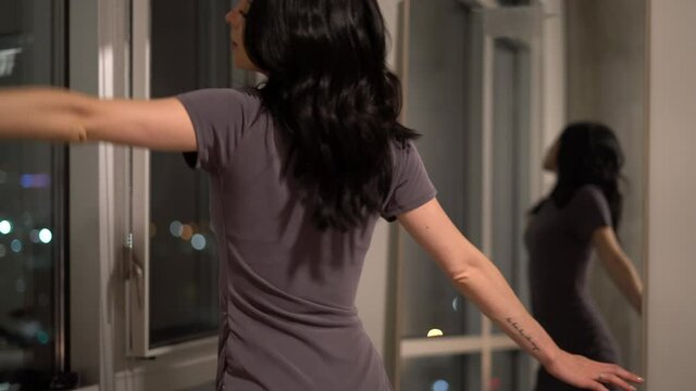 Happy Woman Dancing in Her Bedroom Alone Above the City Lights - Concept: Night out, successful, content, fulfilled, happy dance, relief, money, materialist, luxury lifestyle