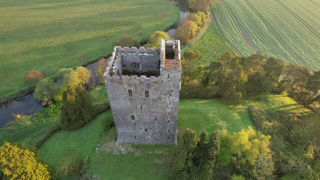 Aerial view of Conna Castle in county Cork, Ireland, a ruined five storey square tower house about 85 feet tall built in 1550, overlooking the River Bride