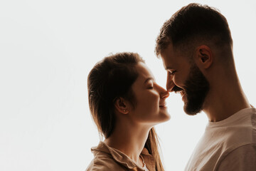 Stylish bearded guy hugging his beautiful girlfriend on the studio background