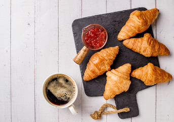 Coffee white cup, croissants on white wooden table background, selective focus. Breakfast concept