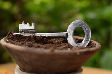 KEY IN FLOWER POT WITH MUD 