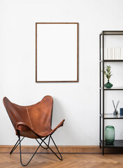 Blank picture frame mockup in interior design. Living room, chair with bookcase. View of modern...