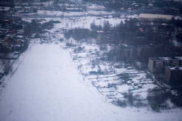 Fototapeta na wymiar View of the snow-covered suburbs of Moscow from an airplane