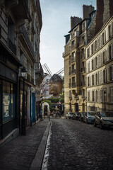 cobblestone street and old moulin in montmartre paris 