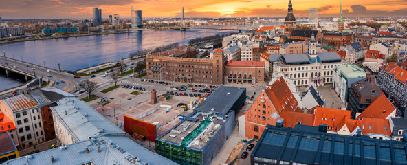 Beautiful aerial view of the Riga old town with St. Peters cathedral in the center and epic sunset sky.