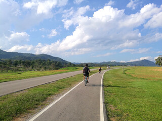 Obraz premium Sport activity ride bicycle on bicycle lane in the parks with Cloud blue sky at singha park , chiang rai , thailand - Travel park and Outdoor 