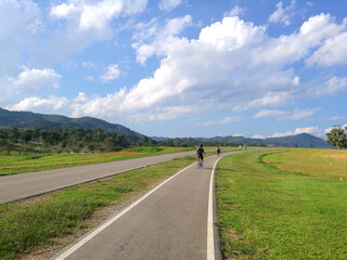 Fototapeta na wymiar Sport activity ride bicycle on bicycle lane in the parks with Cloud blue sky at singha park , chiang rai , thailand - Travel park and Outdoor 