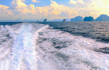 Strong wave behind the moving speed boat with landscape view