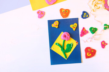 Homemade greeting card, flower and hearts from paper and clay, plasticine as gift for Mothers day, Birthday or Valentines day . Arts  crafts concept. Place for text. Kid craft. Home Education game.