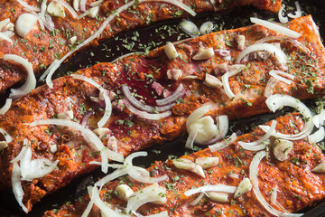 Tasty ribs strip garnished with garlic onion spices and red wine. Food preparation.