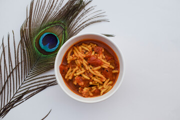 Famous and Authentic Gujarati food Sev tamatar or Sev tameta sabji made out of tomato vegetable and gramflour vermicelli. Indian side dish cuisine on white background