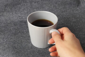 コーヒーカップを持つ女性の右手