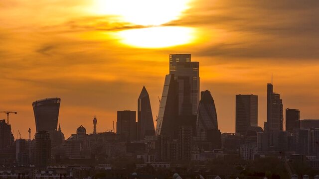 otion time lapse view to the skyline of the City of London during an intense sunset with red and orange cloudscape, United Kingdom