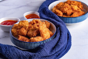 Crispy Chicken Pops Korean Style with Ketchup Chili sauce. Dark tone.