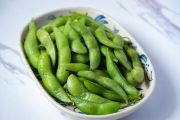 Japanese food edamame nibbles, boiled green soy beans