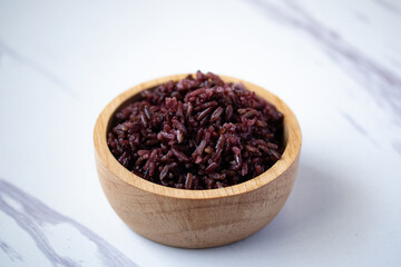 Close-up. Riceberry rice in a wooden bowl.