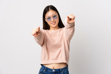 Young Chinese girl over isolated white background pointing front with happy expression