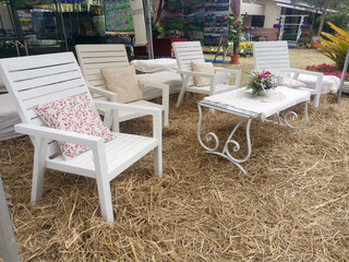 White wooden reception table with multicolored pillows to support straw, restaurant concept to welcome customers in summer.