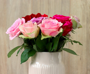 bouquet of differently colored roses in a ceramic vase