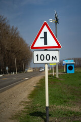 road sign intersection. turn left. the road sign starts working after a hundred meters