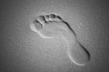 A man's bare footprints in the sand. The trail of a man. Concept: the footprint of the path.
