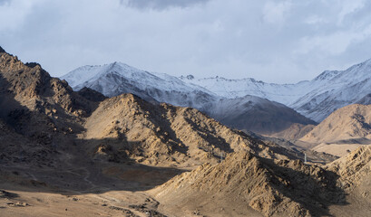 beautiful landscape of mountains with sun over them in ladakh. captured during snowfall.