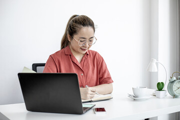 A female company worker sitting in her home office, her company has measures to work from home to prevent the spread of the COVID-19 virus. The idea of working from home.