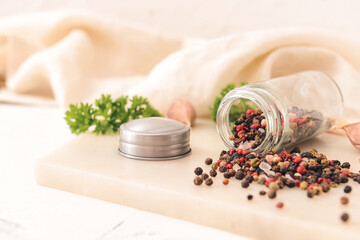 Jar with peppercorns on light background