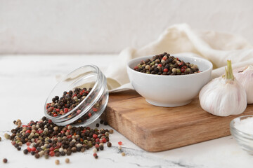 Bowls with peppercorns on light background