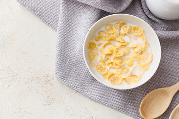 Bowl with tasty cornflakes on light background