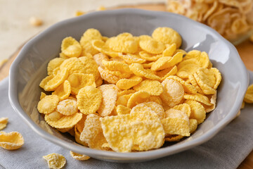 Bowl with tasty cornflakes on light background, closeup